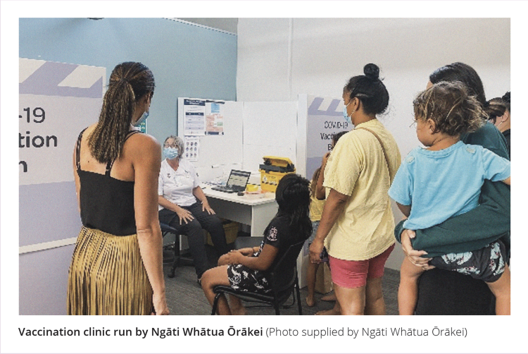 Vaccination clinic run by Ngāti Whātua Ōrākei. This picture shows a family waiting to receive vaccinations at the clinic. All adults are wearing blue medical face masks.