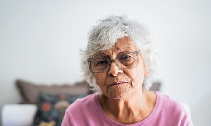 Elderly lady centered in image facing forward.